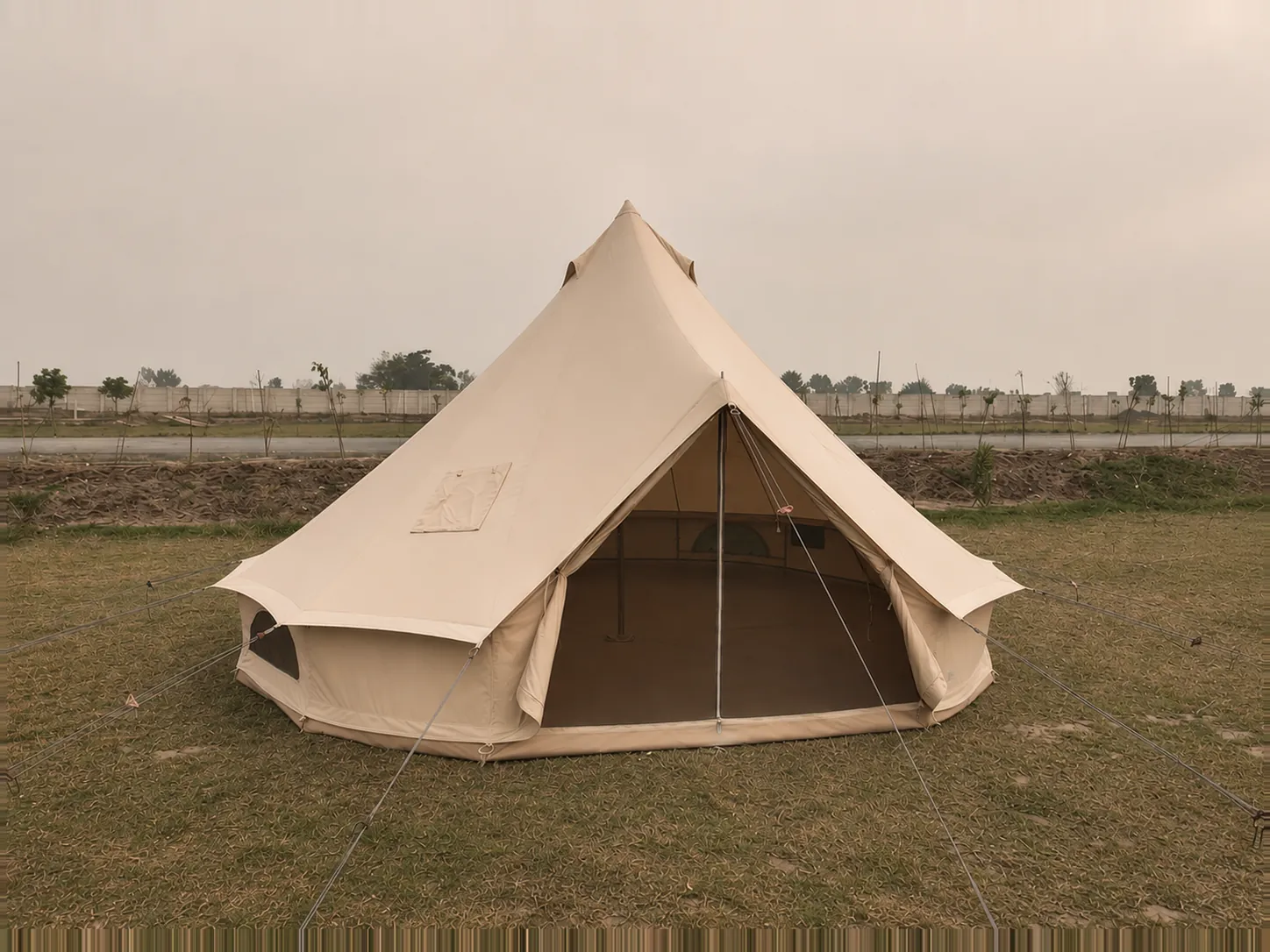 A five metre bell tent pitched on grass with the door open